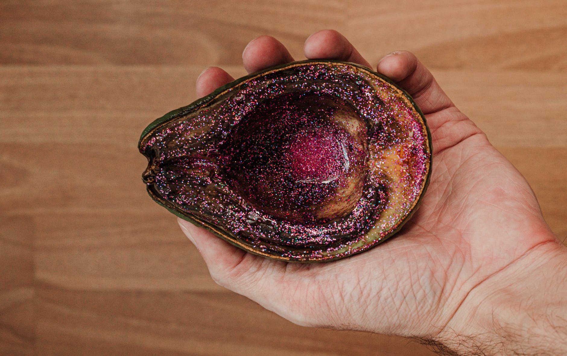 man showing rotten avocado with pink glitter