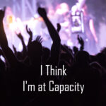 I Think I'm at Capacity busy crowd scene. text I think I'm at capacity