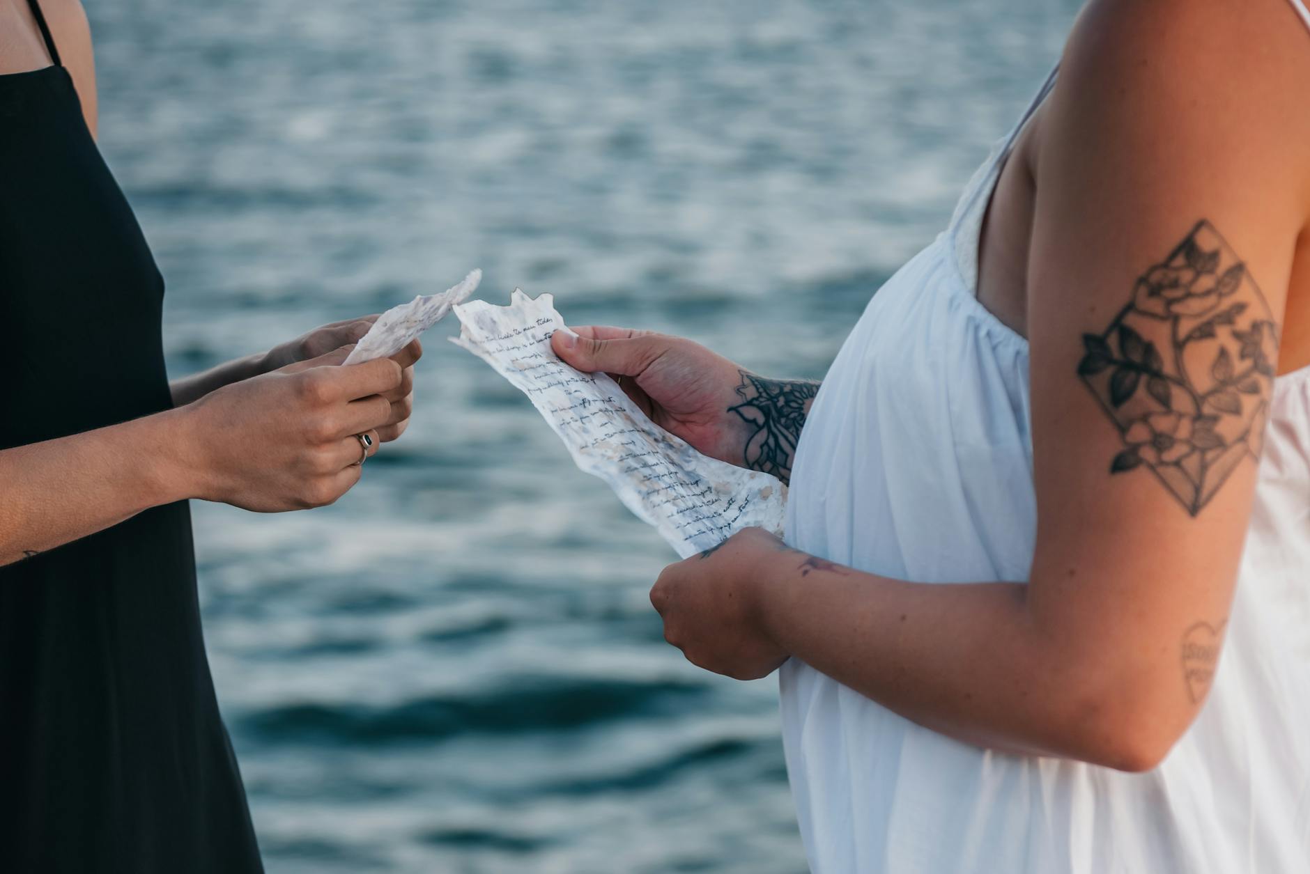 closeup of women holding letters by the sea