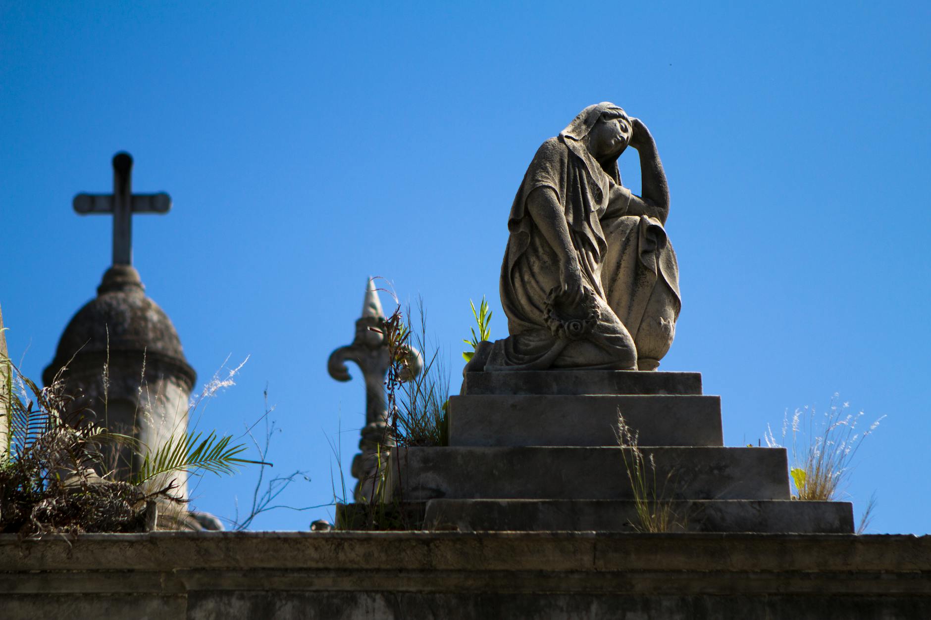 woman statue near cross during daytime
